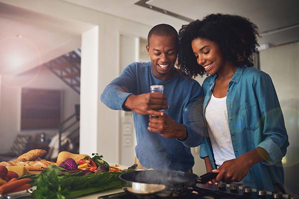 Two people preparing food in a kitchen with air conditioning