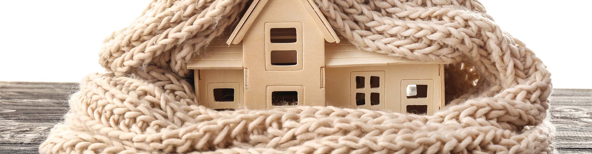 A model house wrapped in a scarf symbolizing heating services